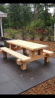 a wooden picnic table sitting on top of a cement slab