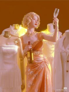 a woman holding a wine glass next to two mannequins