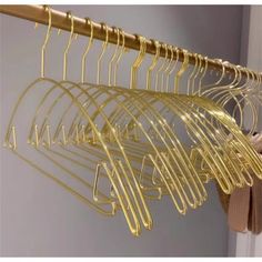 some gold colored clothes hangers on a wall