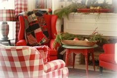 a living room filled with furniture and a fire place covered in christmas greenery next to a fireplace