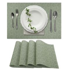 a place setting with green napkins, silverware and a white plate on it