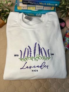 taylor swiftie merch sweatshirt. This lavender haze embroidered sweatshirt is the perfect addition to any Swiftie's wardrobe. The beautiful purple threads provide a subtle nod to recent albums, midnights. It makes for a great gift for any fan, or a cozy spring sweatshirt for yourself. With its wildflower design, this sweatshirt is both cute and stylish. Don't miss out on this must-have piece of subtle merch. ** Unisex sizing. Please size up in you want an oversized fit. A sturdy and warm sweatsh Machine Embroidered Cotton Sweatshirt For Streetwear, Cotton Sweatshirt With Machine Embroidery For Streetwear, Lavender Crew Neck Sweatshirt For Fall, Lavender Cotton Crew Neck Sweatshirt, Lavender Cotton Sweatshirt For Fall, Embroidered Lavender Cotton Top, Embroidered Cotton Lavender Top, Spring Crewneck, Spring Sweatshirt