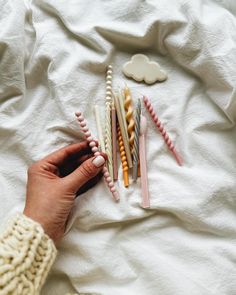 a person laying on top of a bed next to toothbrushes