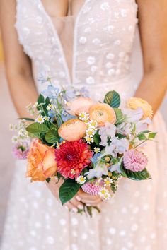 a woman holding a bouquet of flowers in her hands