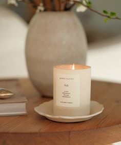 a white candle sitting on top of a wooden table