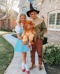 a man and woman dressed up as scarecrows pose for a photo in front of a house