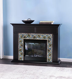 a fireplace with a bowl on top of it in front of a blue painted wall