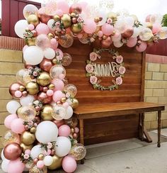 a bunch of balloons that are in front of a bench with a sign on it