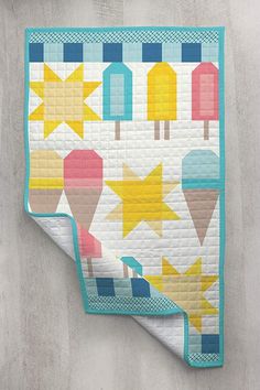 a quilted wall hanging with an ice cream cone and stars design on the front