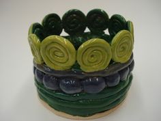 a green and blue bracelet with spirals on it