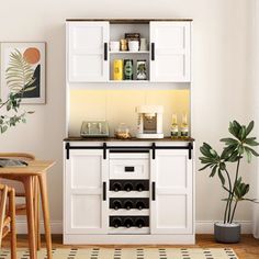 a small kitchen with white cabinets and black counter tops, along with a potted plant in the corner