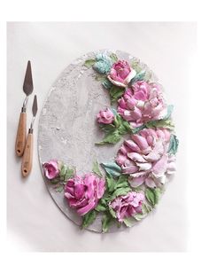 a plate with pink flowers on it next to a pair of scissors and a knife