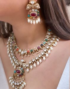 The majestically handcrafted Navratan Polki layered necklace set is based on gold plating that celebrates the rich heritage of Indian jewelry. The Indian Polki necklace set is a masterpiece inspired by Bollywood jewelry to give you a royal look. The bold and bright design of the necklace is perfect for all the beautiful brides to be! Pair this replica of a Sabyasachi jewelry necklace set with your ethnic or contemporary ensembles and create a look to remember. Necklace Closure - Lobster Hook Earrings Closure - Push Back Style Tip - Looks best when worn with your royal whites, off whites, and gold. We love teaming this with classy chiffon sarees or zari silk sarees. We recommend styling with pastel solids or floral dresses in peachy pink, pistachio green, and pastel blue too. A perfect fit Navratan Polki Necklace, Multi-stone Necklace For Wedding And Diwali, Elegant Multi-stone Necklace For Diwali, Fusion Multi-stone Jewelry For Diwali, Fusion Style Multi-stone Chandbali Jewelry, Fusion Style Chandbali Multi-stone Jewelry, Elegant Multi-stone Jewelry For Diwali, Traditional Handmade Jewelry For Reception, Handmade Temple Jewelry For Reception