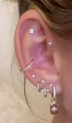 a close up of a person's ear with some piercings on it,