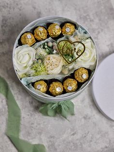 a round metal container filled with chocolates and flowers