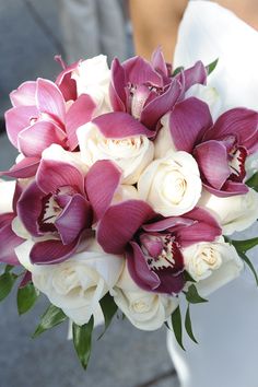 a bridal bouquet with white roses and purple orchids on the bride's wedding day