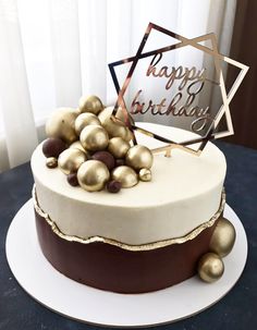 a white and brown cake with gold decorations