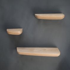 two wooden shelves on the wall with one shelf above them and another shelf below it