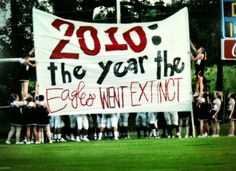 a group of cheerleaders holding up a sign that says 2010 the year the eagles went extinct