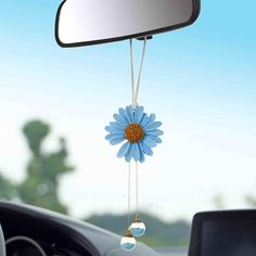 a blue flower hanging from the side of a car mirror