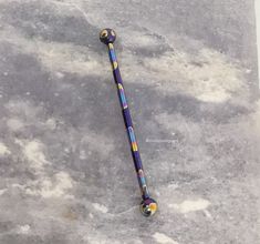 an odd looking metal object sitting on top of a cement surface with white clouds in the background