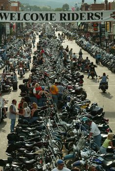 a large group of motorcycles parked on the side of a road next to each other