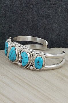 This stunning turquoise and sterling silver bracelet was made by Navajo silversmith Leslie Nez. The inside is signed Leslie Nez and stamped sterling.Size: 5 3/4" (will fit up to a 7" wrist)Gap: 1 1/4"Width: 1"Free shipping on all orders! We ship with USPS and always include tracking. All orders ship within a day of payment.Returns are accepted up to 30 days after you receive your order. Just send us a message. Our shop offers cash back or store credit. The item must be returned in new condition. Western Style Blue Bangle Jewelry, Southwestern Blue Nickel-free Cuff Bracelet, Southwestern Style Nickel Free Blue Cuff Bracelet, Southwestern Style Blue Nickel-free Cuff Bracelet, Southwestern Blue Oval Bracelets, Southwestern Style Sterling Silver Bracelet, Southwestern Style Turquoise Bracelet Stamped 925, Collectible Bohemian Blue Sterling Silver Bracelet, Southwestern Turquoise Sterling Silver Cuff Bracelet