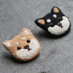 two small crocheted animals sitting on top of a gray carpet next to each other