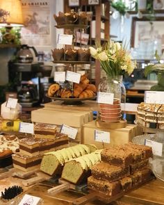 there are many different types of cakes on the counter in this store, including cake slices