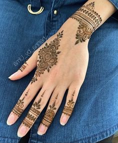 a woman's hand with henna tattoos on it