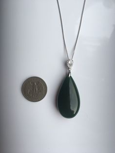 A gorgeous dark green jade pendant necklace. The big teardrop pendant comes with shiny diamond-like small teardrop stones and a 925 sterling silver necklace. Simple but elegant. Perfect as a gift for yourself or your loved ones. Highlights of this breath-taking teardrop round jade pendant are: ＊High-quality materials Made from quality jade and 925 sterling silver. Friendly to sensitive skins and ensure long-lasting color ＊Simple & Elegant Minimalistic style goes well with all sorts of occasi Green Drop Necklaces In Fine Jewelry Style, Elegant Dark Green Jade Jewelry, Green Jade Teardrop Pendant Jewelry, Elegant Green Teardrop Necklace, Elegant Green Teardrop Pendant Jewelry, Elegant Green Pendant Drop Necklace, Elegant Green Gemstone Drop Necklace, Jade Teardrop Pendant Gemstone Jewelry, Green Teardrop Gemstone Drop Necklace