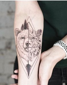 a woman with a bear and flower tattoo on her arm is holding the other arm