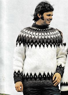 a man standing next to another man wearing a sweater with an interesting pattern on it