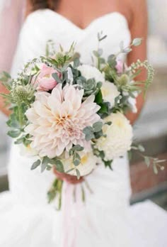 a bride holding a bouquet of flowers on her wedding day