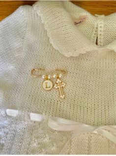 a white sweater with two charms attached to it