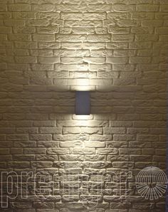 a brick wall with a lamp on it in front of the light shining from behind