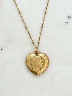 Our lovely Virgin Mary Heart Medal Necklace! 🌹 This smooth heart medal features the face of a young Mary. The beauty of this piece lies in how subtle and simple it is. Experience the beauty and grace of our Virgin Mary Heart Pendant Necklace. Order now and adorn yourself with a touch of divine beauty ✨ Size and Material: -Features a charming 23mm x 25mm heart medal - Medal is crafted from durable pewter and plated with authentic 12k gold - 16" chain with 2" extender - 14k gold over brass chain - Lobster clasp closure for adjustable fit 💝 Each of our necklaces arrives in a beautiful gift box, perfectly ready for giving, just like the one pictured! Jewelry Care: - Our jewelry is delicate. - To keep jewelry looking its best, apply cosmetics, lotions and perfumes before wearing. - We recomme Virgin Mary Heart, Mary Heart, Catholic Necklace, Mother Necklace, Divine Beauty, Antique Gold Jewelry, Mothers Necklace, Blessed Mother, Mother Mary