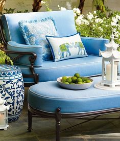 an outdoor patio with blue furniture and white flowers