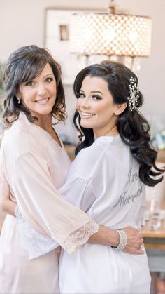 two women standing next to each other in front of a table