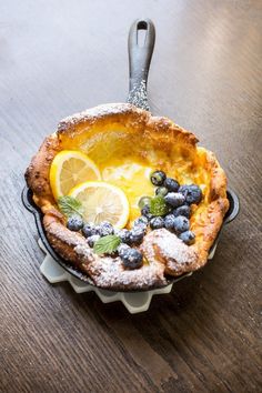 a lemon and blueberry pie with powdered sugar on the rim is ready to be eaten