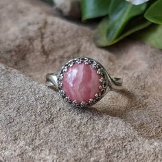 10mm round pink banded rhodochrosite cabochon set in fancy gallery wire bezel sterling silver adjustable ring. Starts at size 8.