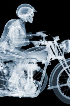 an x - ray image of a skeleton riding a motorcycle on a black background,