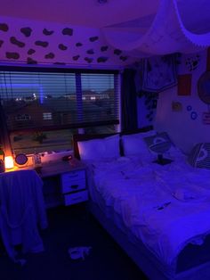 a bed sitting under a purple light in a bedroom