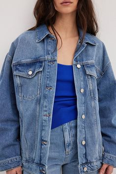 This denim jacket is oversized and made of organic cotton. It has a classic collar, drop shoulders and long sleeves with a button cuff. Our denim jacket features front flap pockets on the chest, open side pockets, an adjustable button detail on the bottom hem and a button closure. Classic Denim Jacket, Double Denim, Future Fashion, Button Detail, Flap Pocket, Drop Shoulder, Women Empowerment, Denim Jacket, Organic Cotton