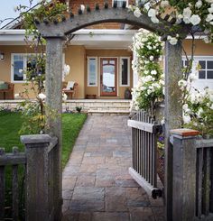 an entrance to a house with white flowers on it