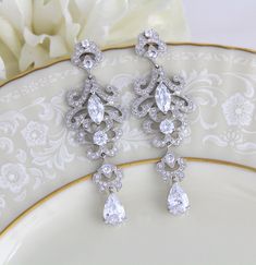 Rose gold cubic zirconia Bridal earrings in a modern vintage style chandelier style. Choose crystal drop or pearl drop from the drop down menu. Earrings are a perfect statement piece for any bride or other special occasion. Earrings measure 3 inches long and are 1 inch at their widest. Available in rose gold or rhodium finish. Back to my shop: https://www.etsy.com/shop/TheExquisiteBride?ref=condensed_trust_header_title_items Glamorous Crystal Chandelier Earrings With Elegant Design, Exquisite Wedding Chandelier Earrings With Cubic Zirconia, Wedding Diamond Drop Earrings With Intricate Design, Exquisite Cubic Zirconia Chandelier Earrings For Wedding, Elegant Drop Chandelier Earrings In Cubic Zirconia, Intricate Design Diamond Drop Earrings For Wedding, Elegant Cubic Zirconia Drop Chandelier Earrings, Intricate Dangle Bridal Earrings With Cubic Zirconia, Intricate Cubic Zirconia Dangle Bridal Earrings