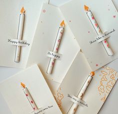 four birthday cards with matches on them, one has an orange candle and the other is white