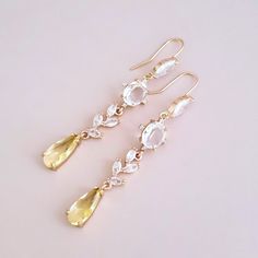 "Gold Yellow Earrings for brides, weddings and bridal showers. The perfect gift earrings for bridesmaids, mother of the groom, or mother of the bride. Find earrings for bridal bachelorette party or other special occasions here. A gentle cascade of shimmering Clear and Yellow crystals in these beautiful  bridal earrings. Adding just a hint of sparkle, this pretty pair make gorgeous earrings for both brides and bridesmaids.  Yellow glass crystals add a fun pop of color and a great way to sneak in a \"something yellow\" into your bridal ensemble. Simply stunning!  These beautiful red statement earrings will complement any bridal style and make the perfect gift for bridesmaids too. The Details: * Made with premium quality crystals * Stones are hand set in secure prongs * Great for brides, brid Gold Dangle Teardrop Earrings For Bridesmaid Gift, Elegant Yellow Chandelier Earrings As Gift, Drop Bridal Earrings For Pierced Ears, Wedding Bridal Drop Earrings For Pierced Ears, Wedding Drop Bridal Earrings For Pierced Ears, Wedding Drop Bridal Earrings, Gold Dangle Earrings For Bridal Shower, Gold Drop Earrings For Bridesmaid Gift, Gold Earrings For Bridal Shower