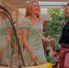 a man and woman standing next to each other holding shopping bags