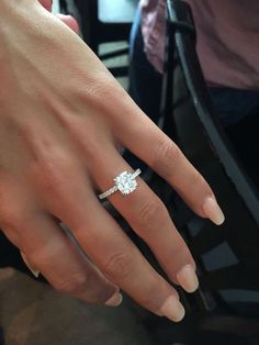 a woman's hand with a diamond ring on it